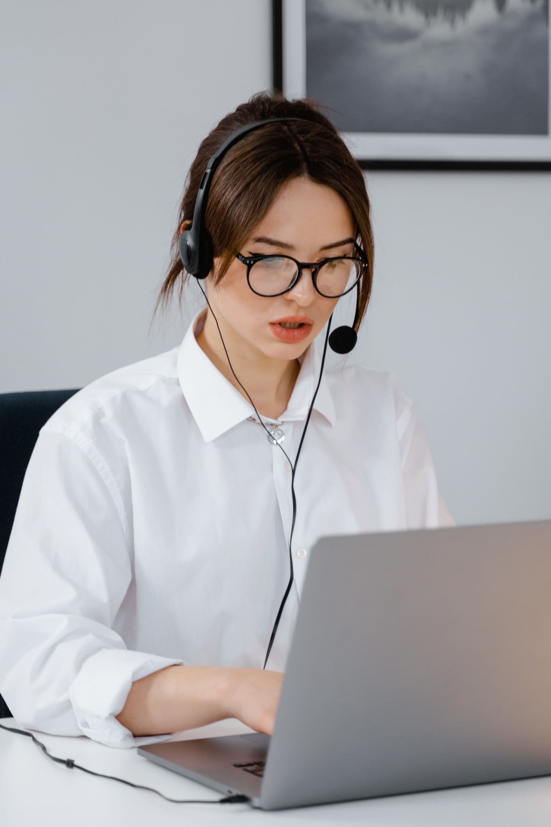 A customer-support agent wearing a headset and working on a laptop in an office. Stock photograph, not an iGaming Operations employee.