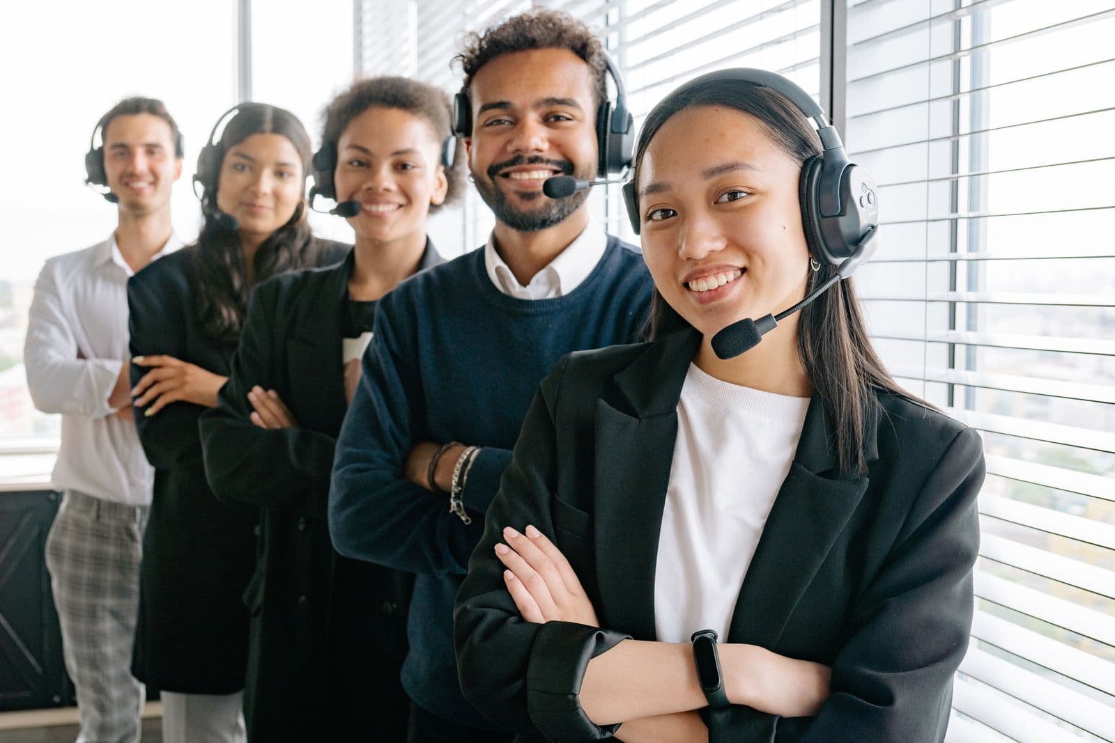 A customer-support agent wearing a headset and smiling during a call. Stock photograph, not an iGaming Operations employee.