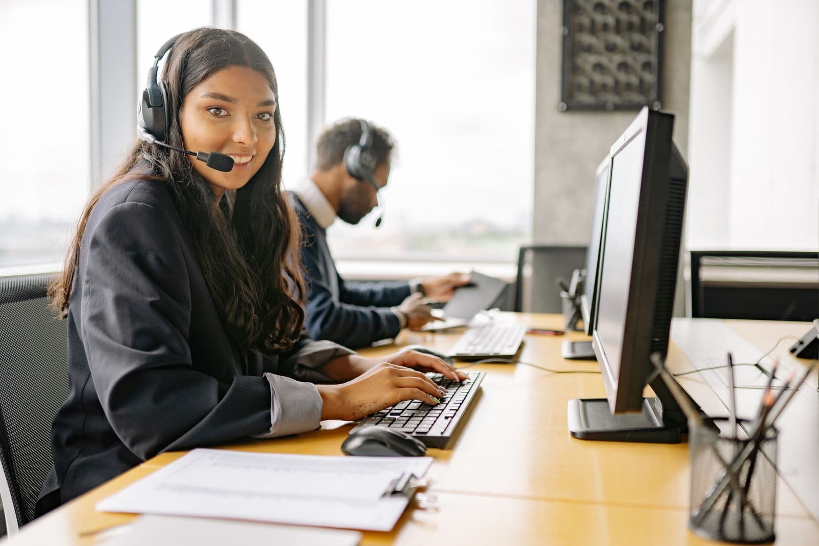 A customer-support agent in profile, wearing a headset at a desk. Stock photograph, not an iGaming Operations employee.